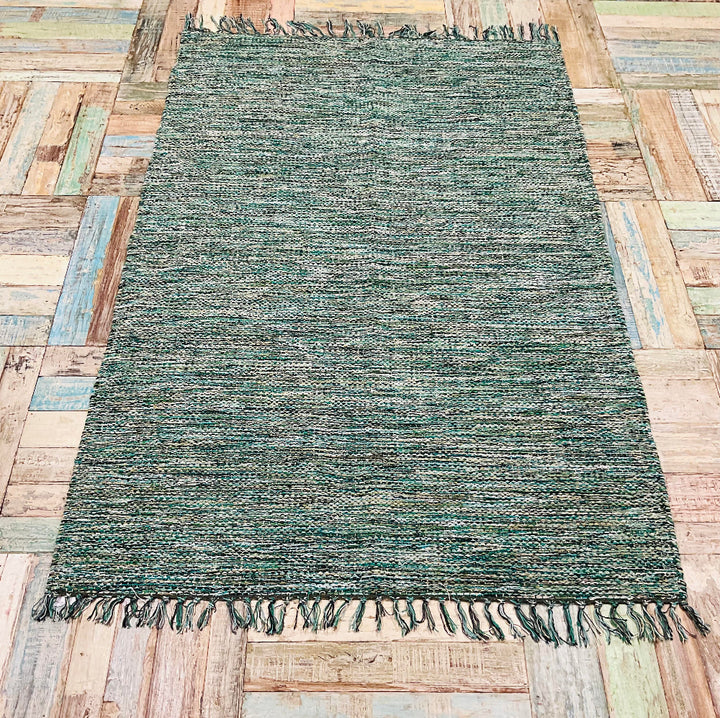 Green Heavy Cotton Rug placed on a recycled wooden floor.
