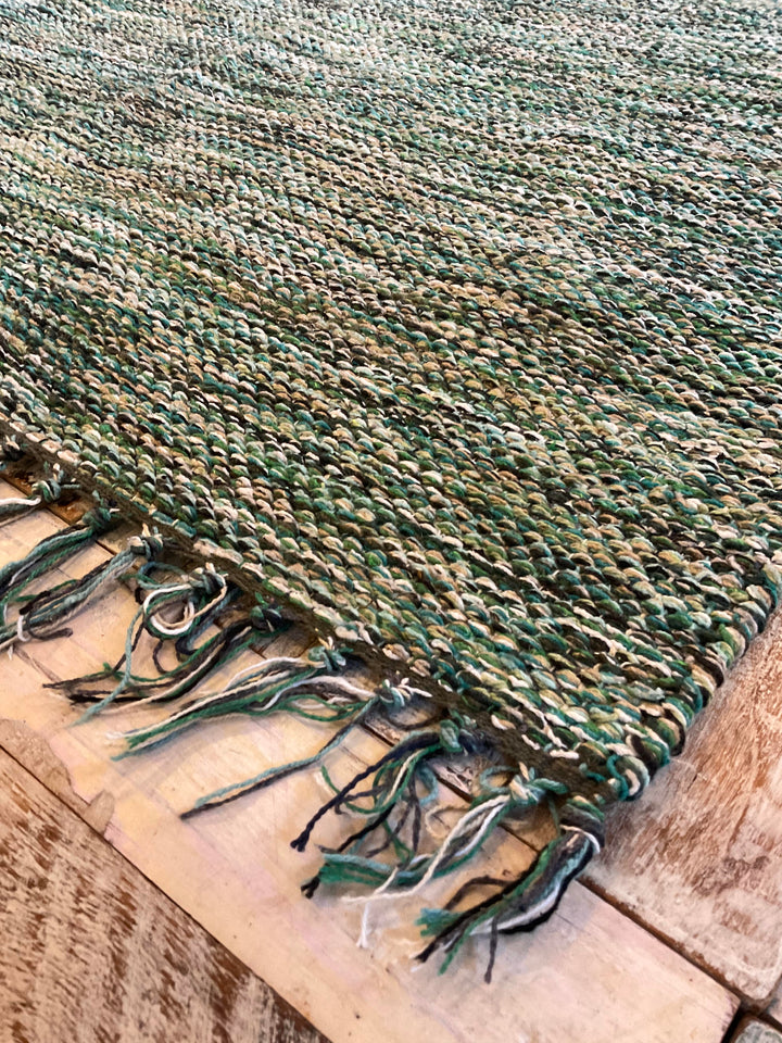 Green Drift Heavy Cotton Rug Close Up of Rug on a wooden floor.
