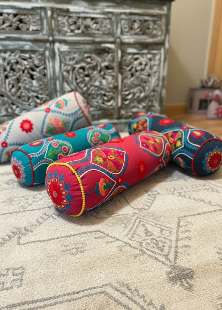Four Bolster Cushions On a Moroccan Rug