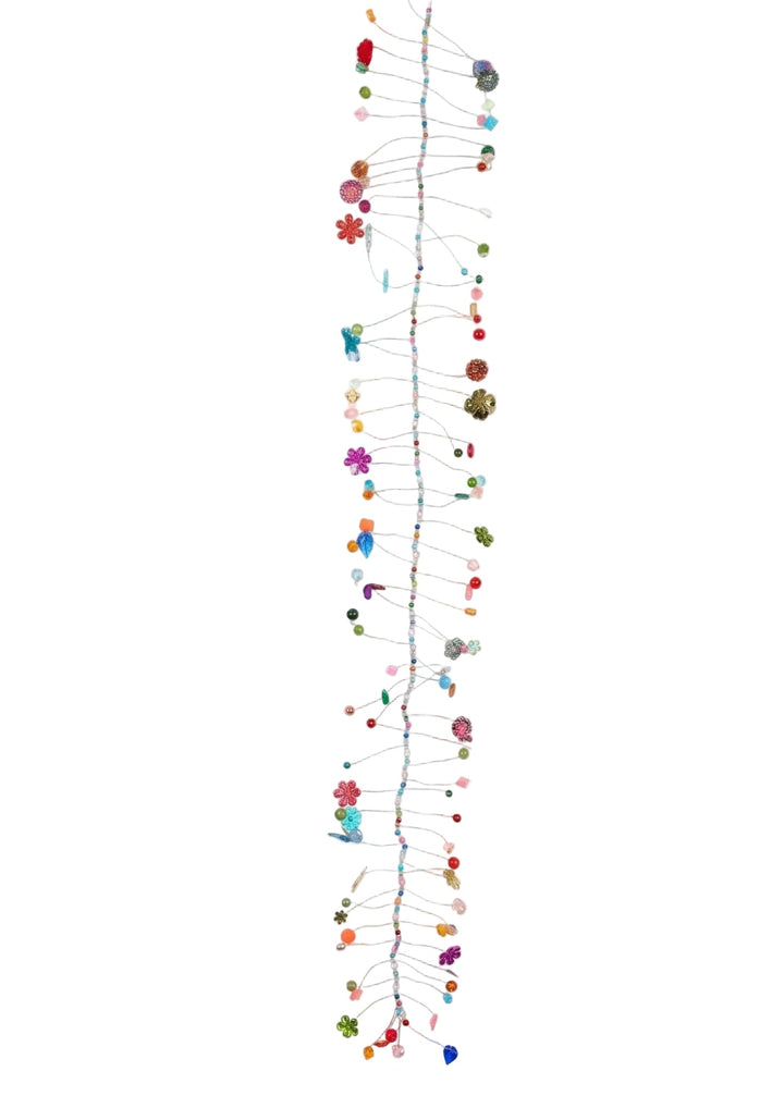 A long vertical hanging wall art piece made of many thin strings with small colorful decorative beads and floral-like accents, photographed against a plain white background.