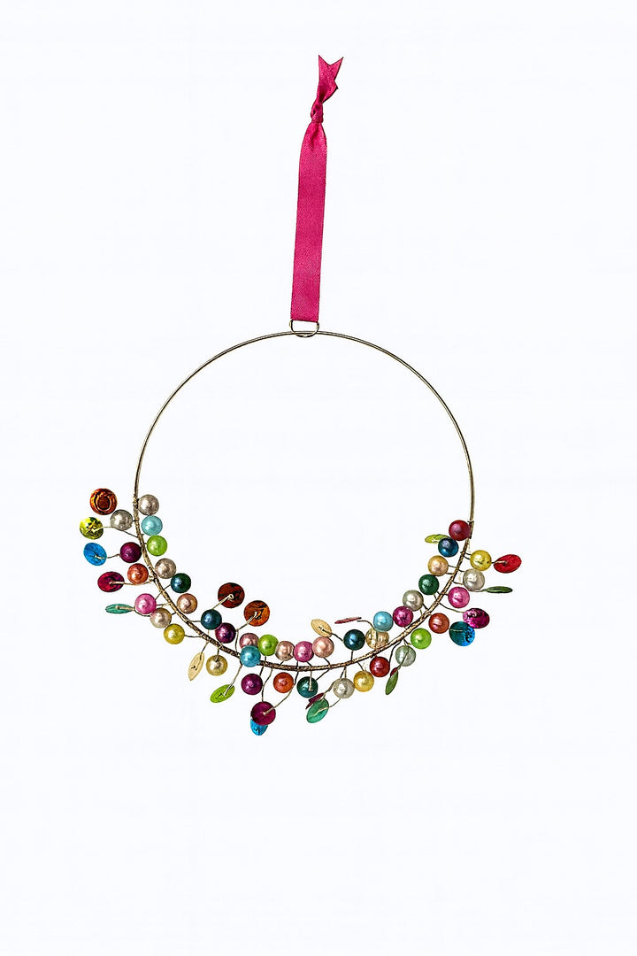 Decorative ornament with colourful beads and a pink ribbon on a white background