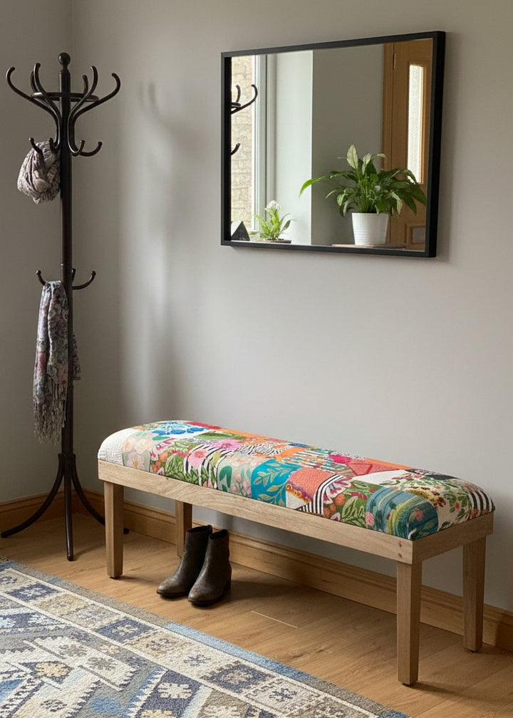 Colourful bench with patterned cushion in a room with a coat rack, mirror, and rug.