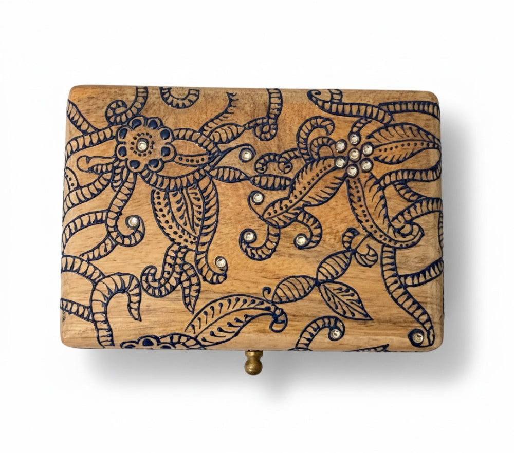 Wooden box with intricate carvings and embellishments on a white background