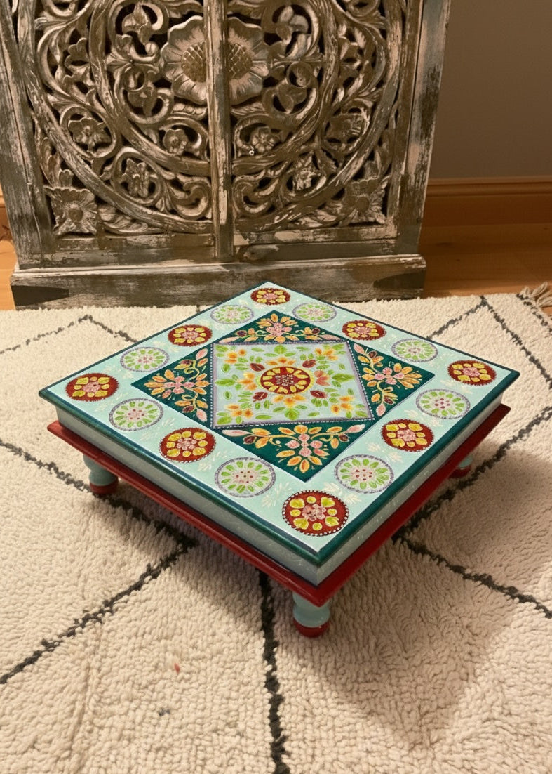Decorative step stool with floral patterns on a textured rug