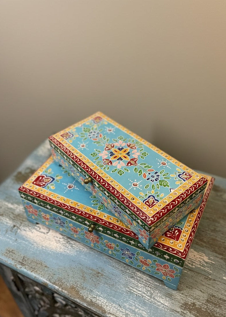 Decorative box with floral patterns on a wooden surface