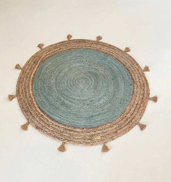 Round woven mat with tassels on a plain background