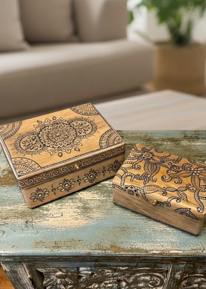 Decorative wooden box with intricate patterns on a rustic table in a living room setting.