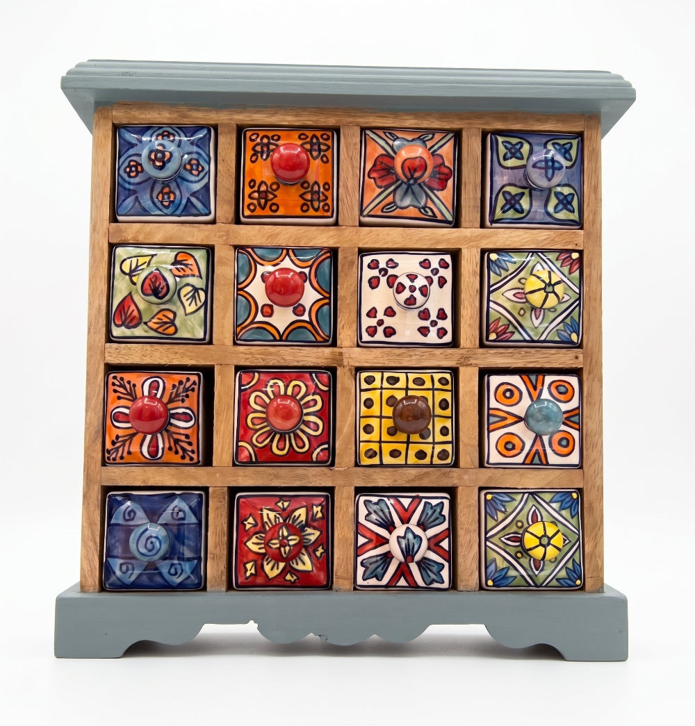 A handcrafted wooden jewellery box with 15 colourful, hand-painted ceramic drawer fronts featuring various traditional Mexican patterns and designs, set against a plain white background.
