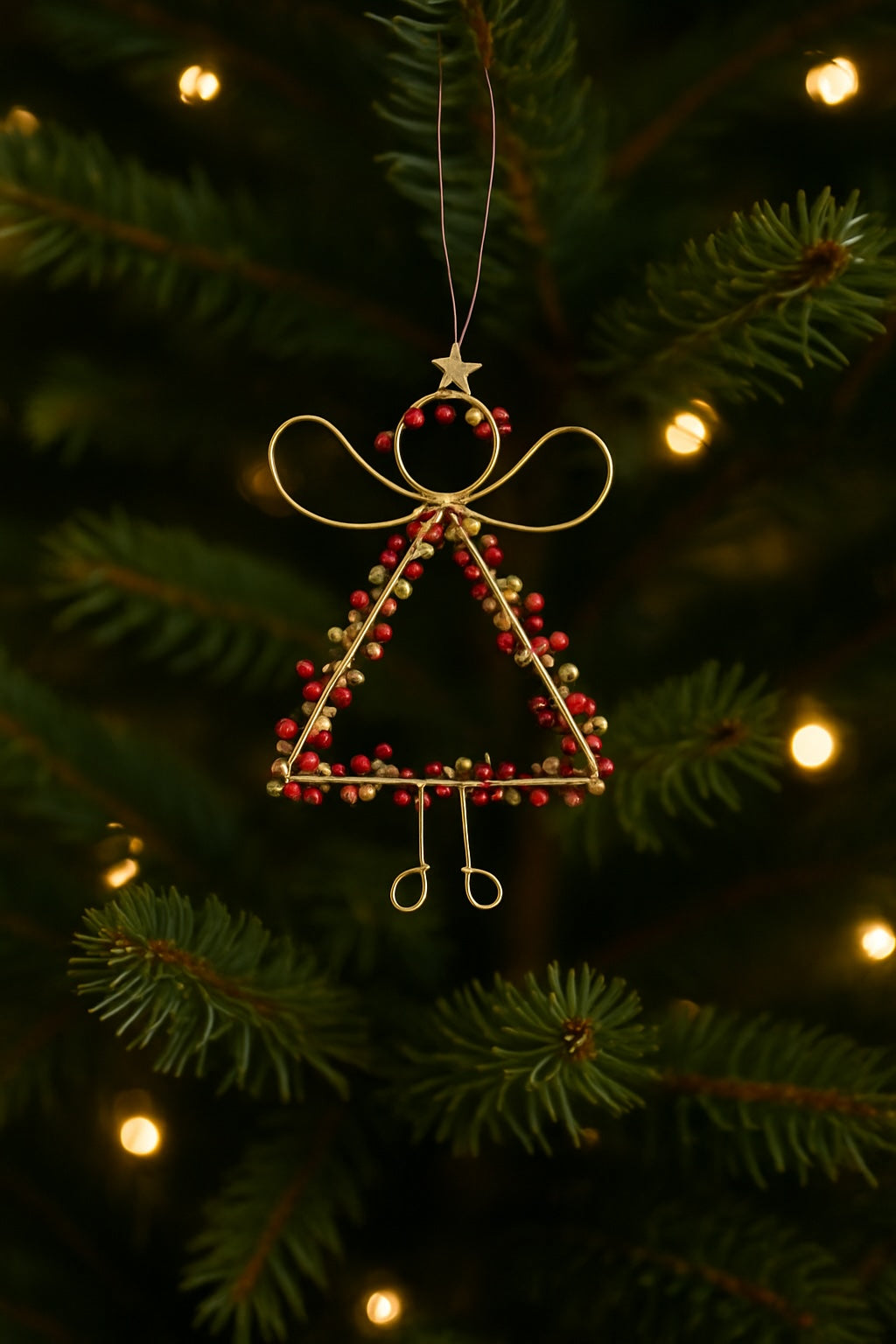 Decorative angel ornament on a Christmas tree with blurred lights in the background