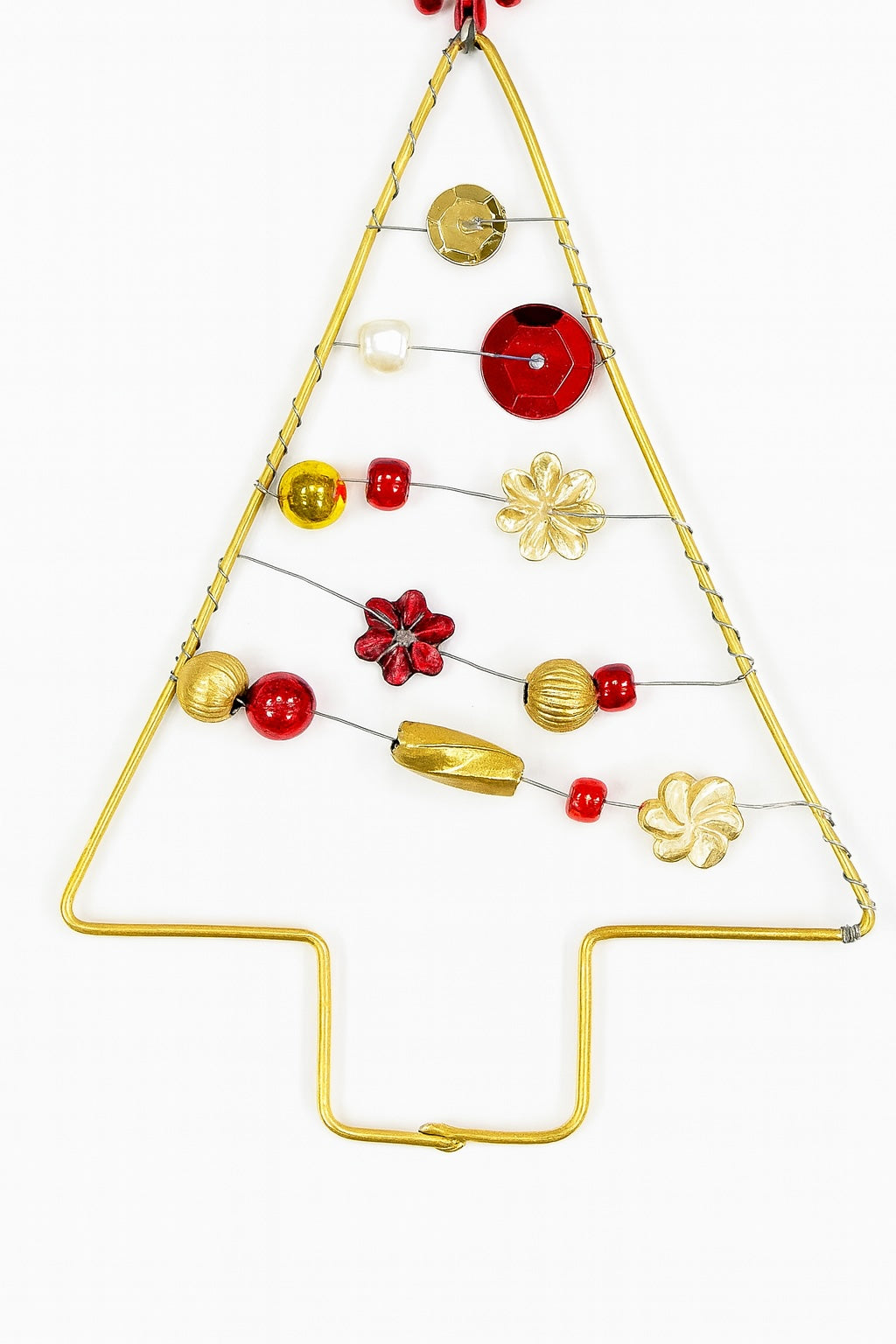Decorative Christmas tree made of gold wire with red and gold ornaments on a white background