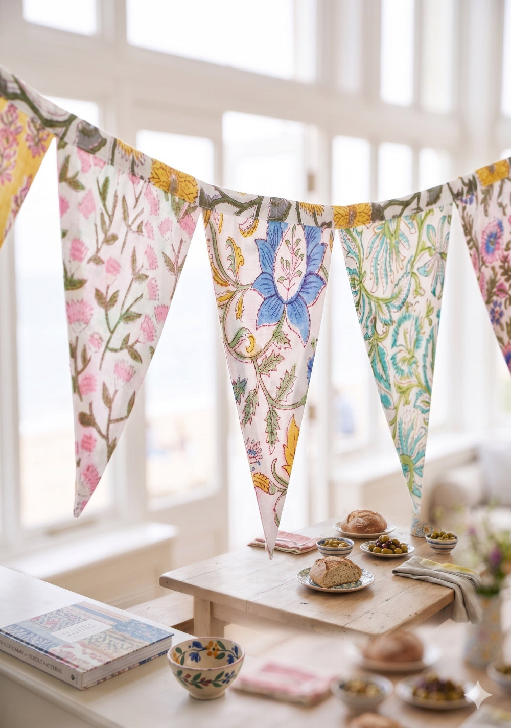 Decorative floral bunting hanging in a room with a table and books.