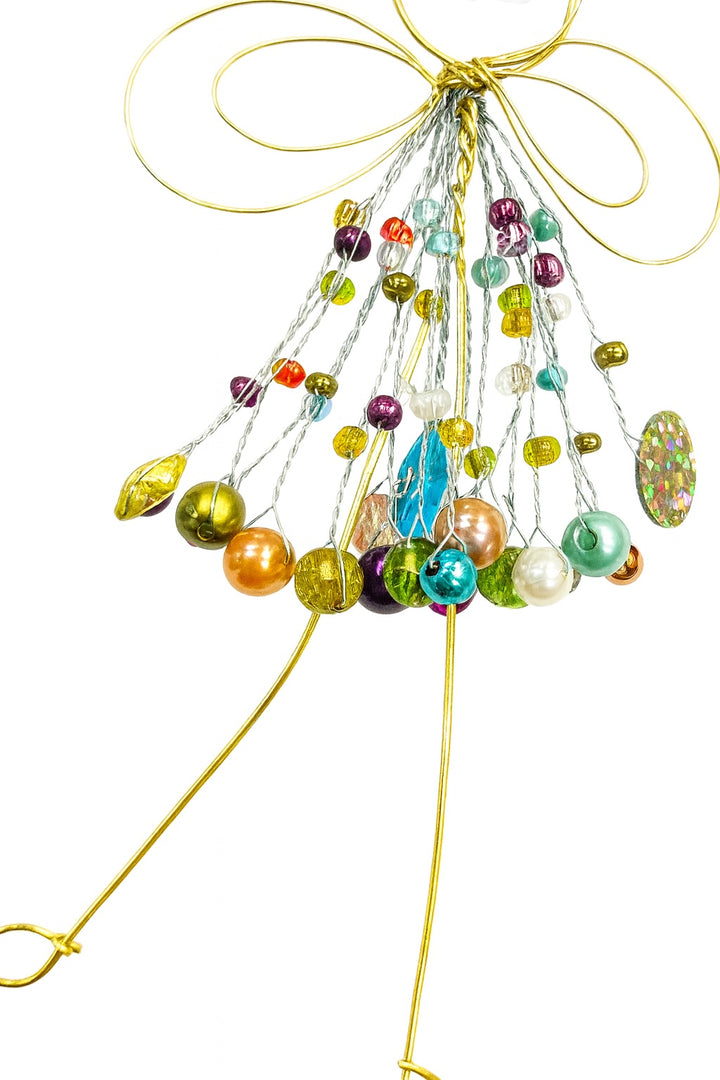 Close Up of Colourful beaded decoration with gold wings on a white background