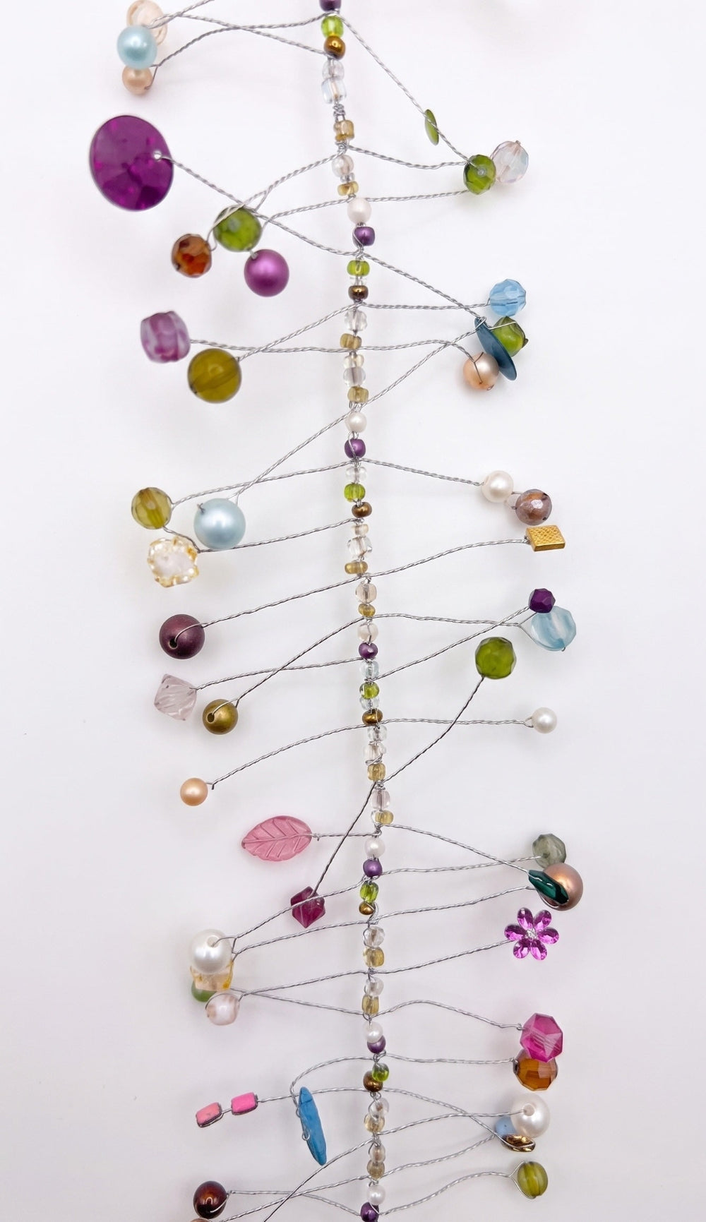 A delicate wire ornament featuring colourful faceted beads, pearls, and glass gems in purple, green, blue, pink, and gold on a white background.
