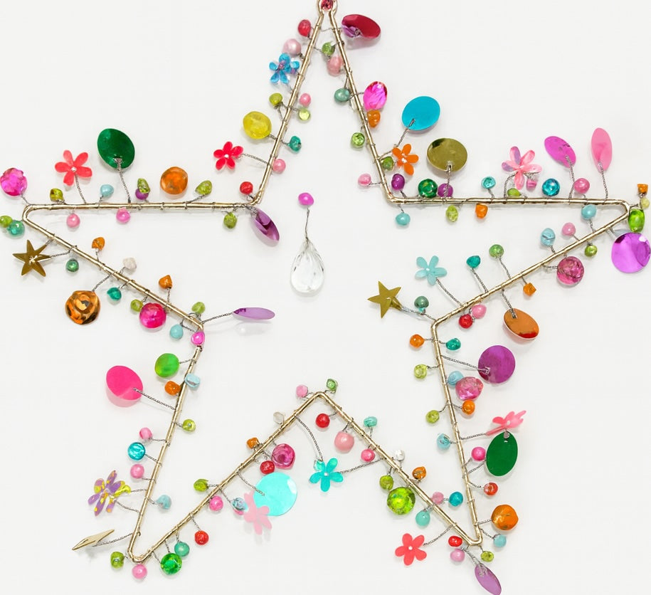 Decorative star made of colourful beads and small flowers on a white background