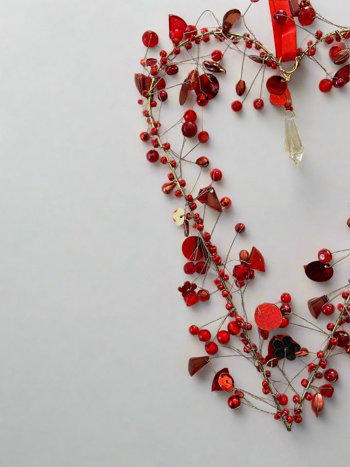 Decorative red berry bead garland on a light grey background