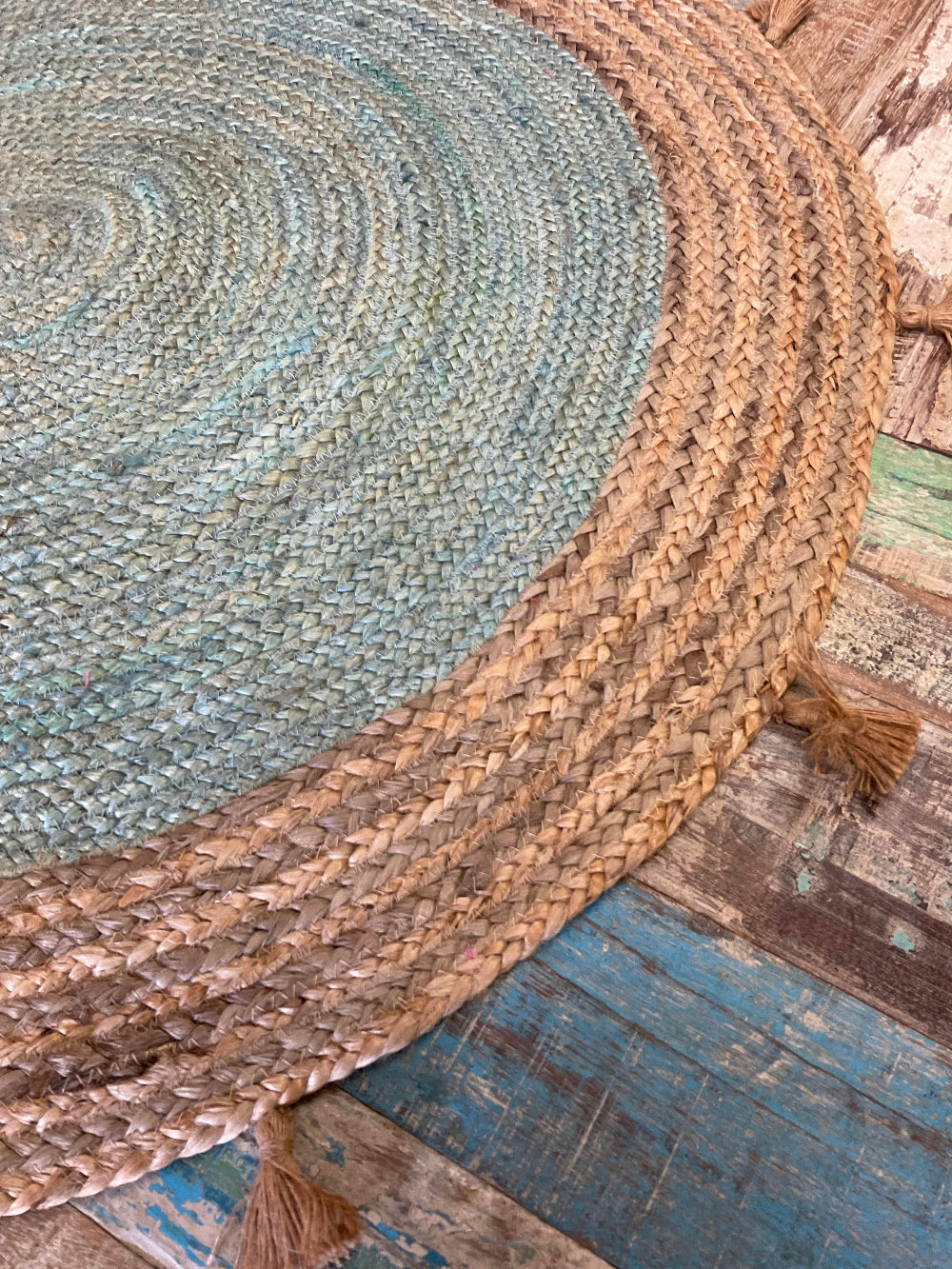 Round braided rug with tassels on a wooden floor