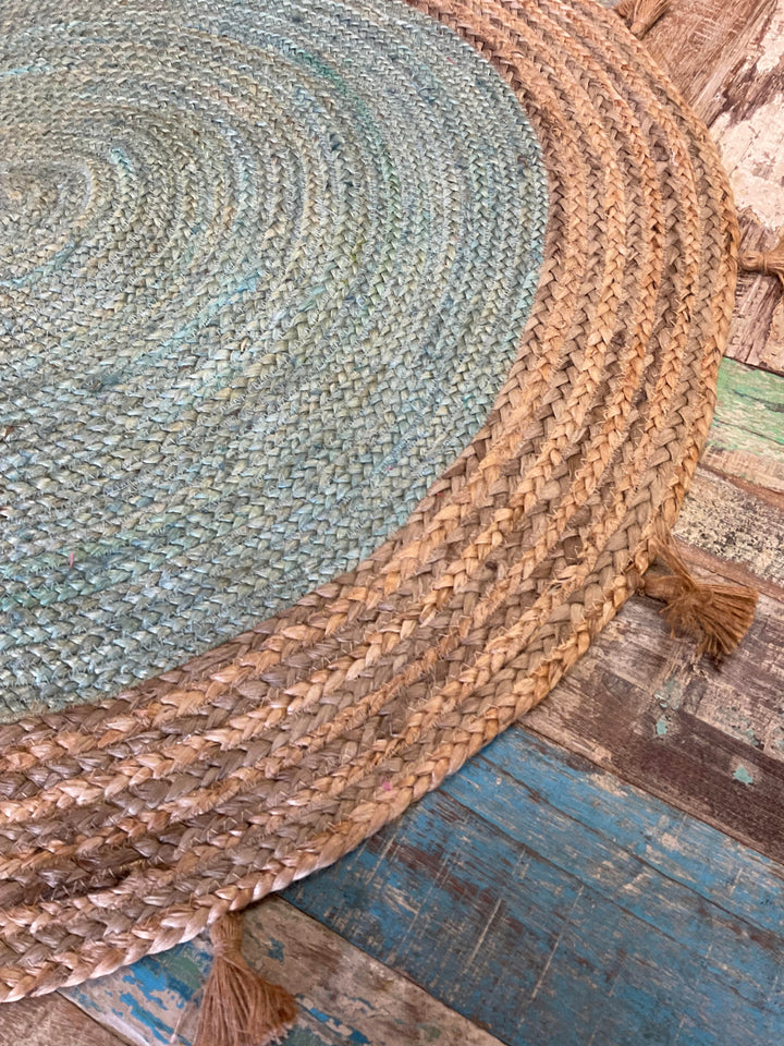 Round braided rug with tassels on a wooden floor