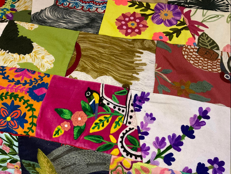 Collection of colourful embroidered fabric samples with various patterns.