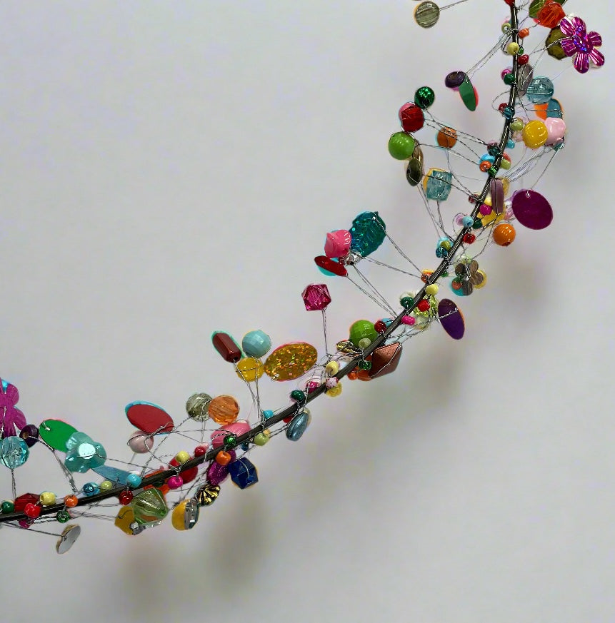 Decorative wreath close up with colourful beads on a plain background