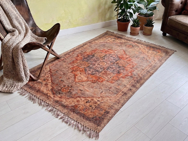 Living room with a patterned rug, wooden chair, and sofa.