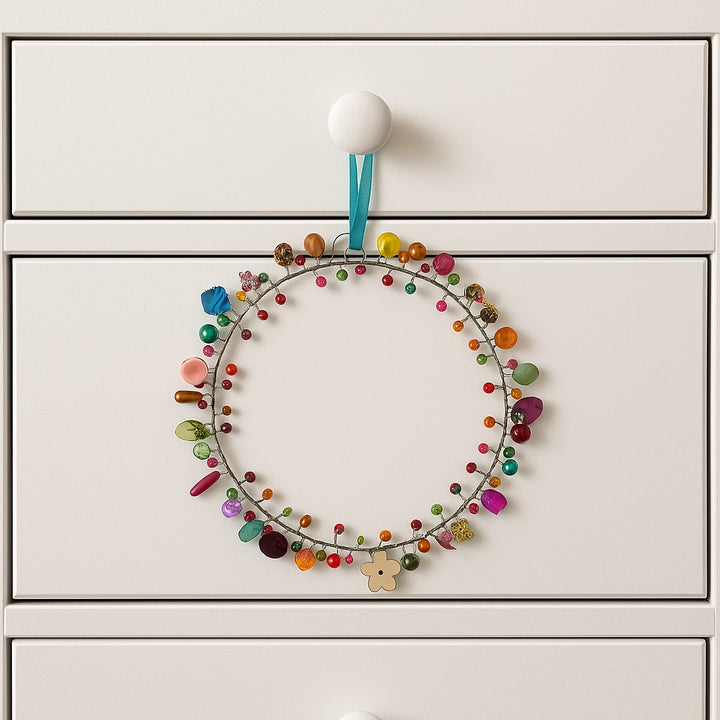 Colorful decorative wreath hanging on a white cabinet door.