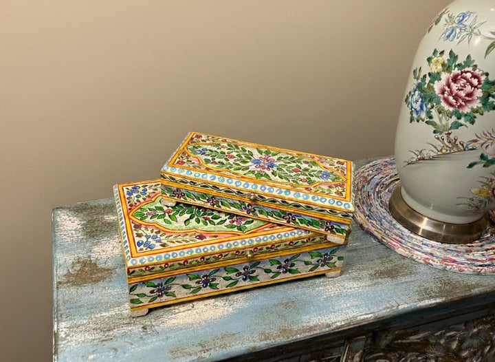 Set of decorative boxes with floral patterns on a textured surface