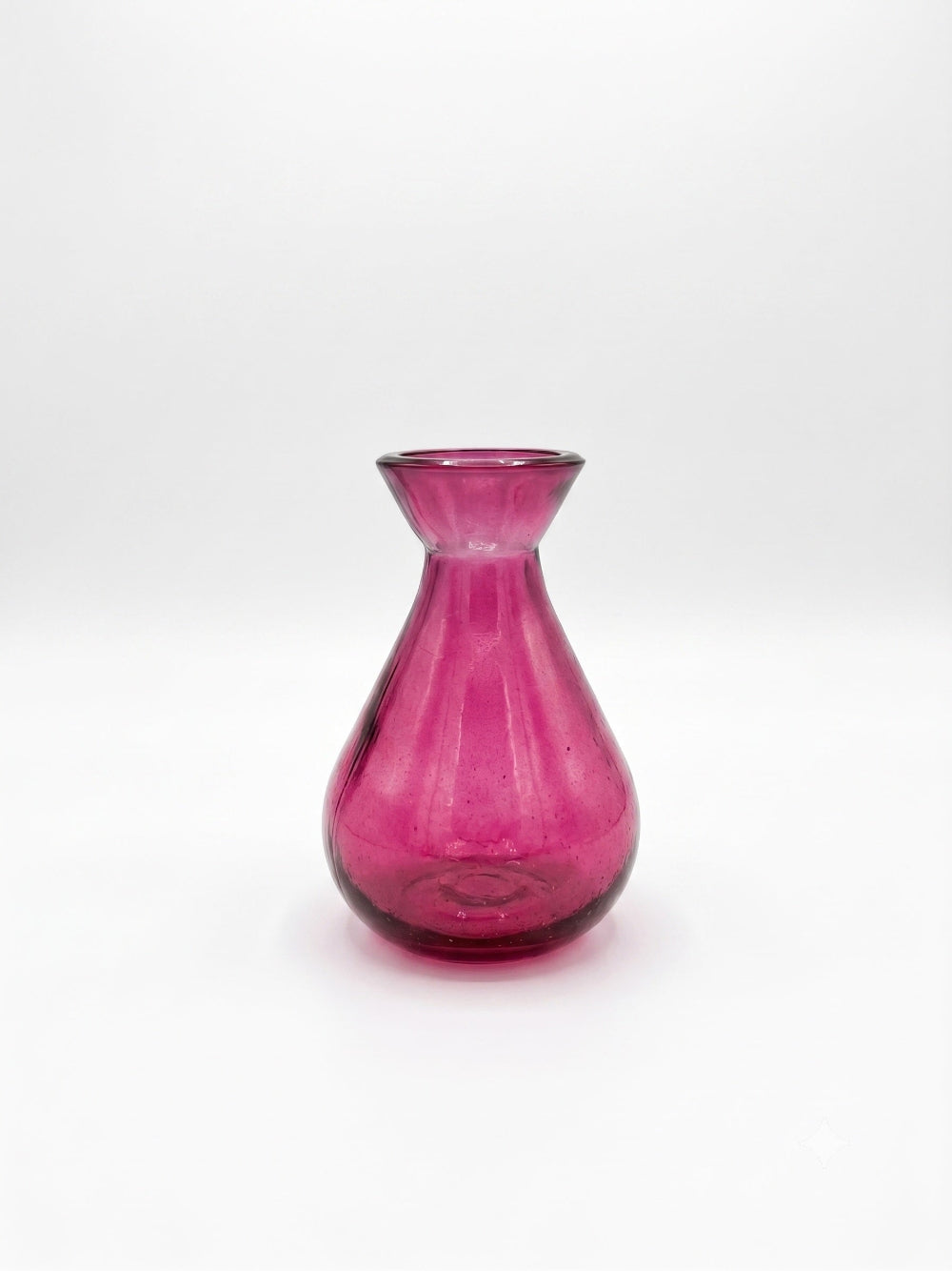 A small translucent pink glass vase with a flared neck and rounded base, photographed against a plain white studio background.