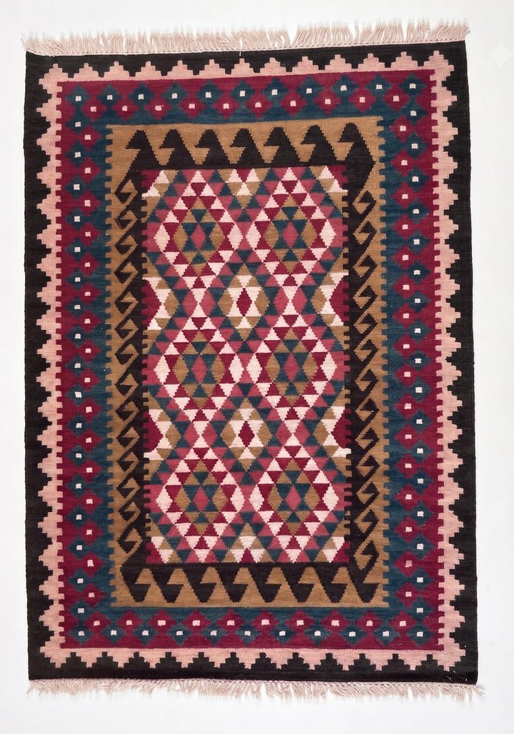 A square kilim area rug with a geometric tribal pattern in pink, red, black, beige, and blue, featuring fringed edges.