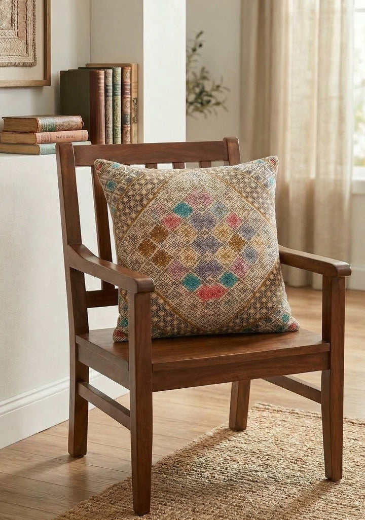 Wooden chair with a patterned pillow in a room with books and a window.