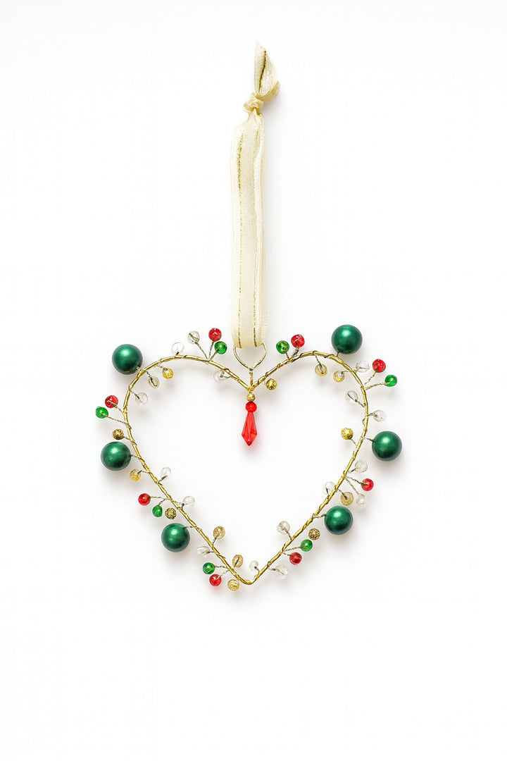 Heart-shaped ornament with green and red beads on a white background