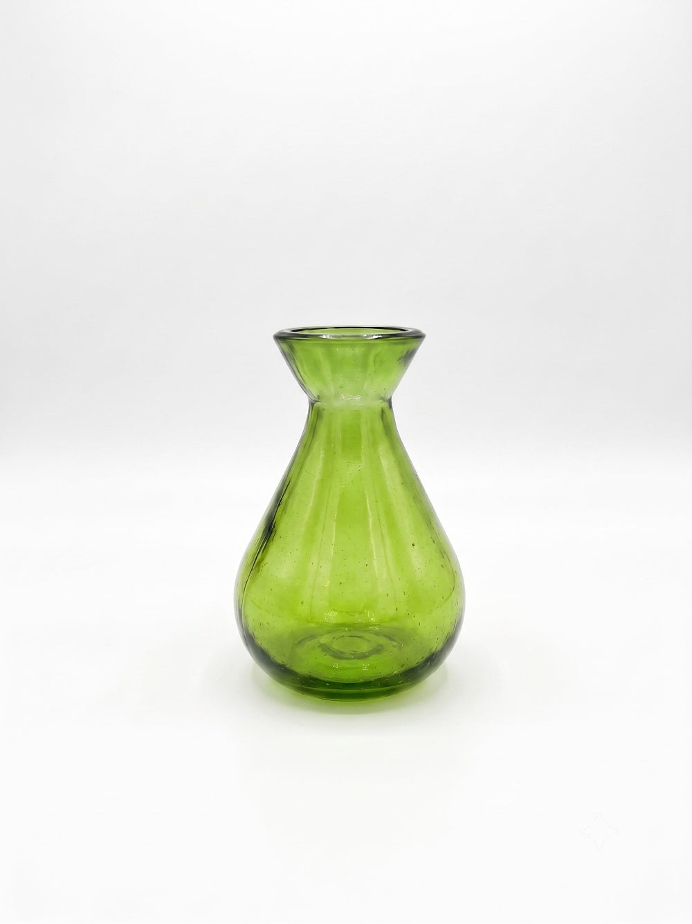 A small translucent green glass vase with a flared rim and ribbed body, centered on a plain white studio background.
