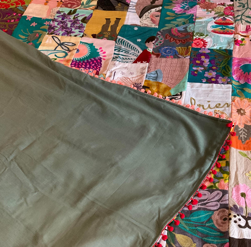 Colorful patchwork quilt with a green fabric swatch on top