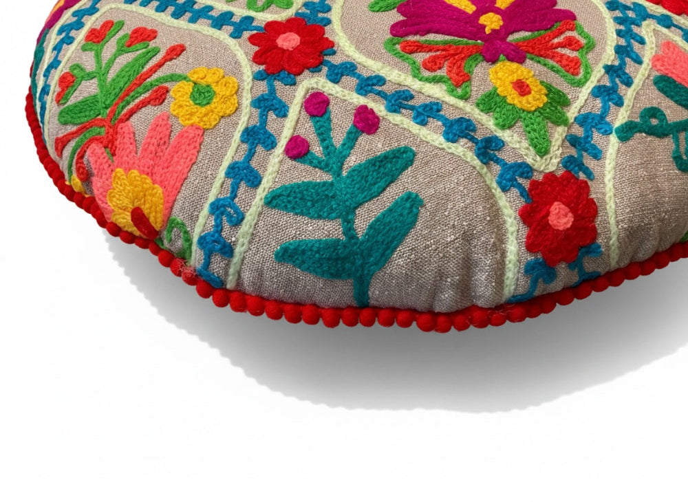 Decorative cushion with colourful floral embroidery on a white background
