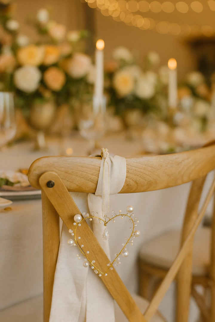 Decorative chair with heart-shaped light holder at a wedding reception table.