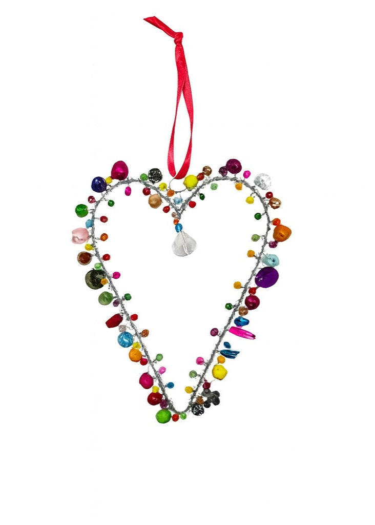 Heart-shaped decorative ornament with colourful beads and a pink ribbon on a white background