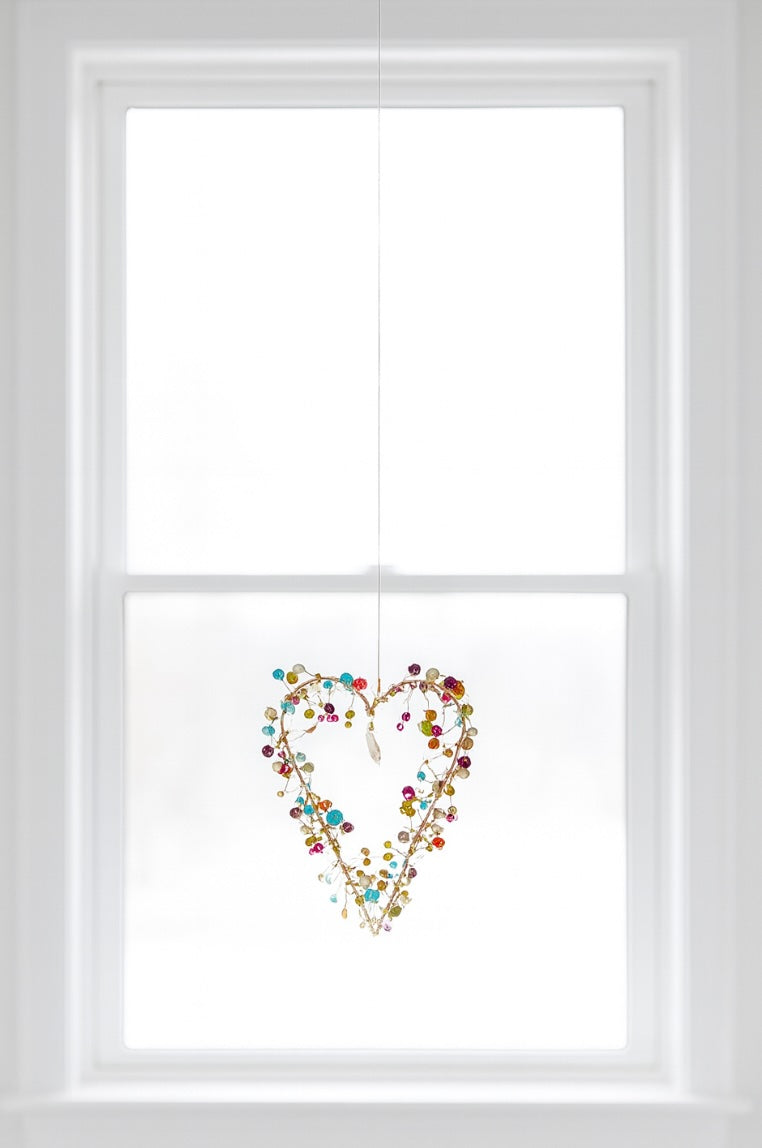 Decorative heart-shaped design on a window with a white frame