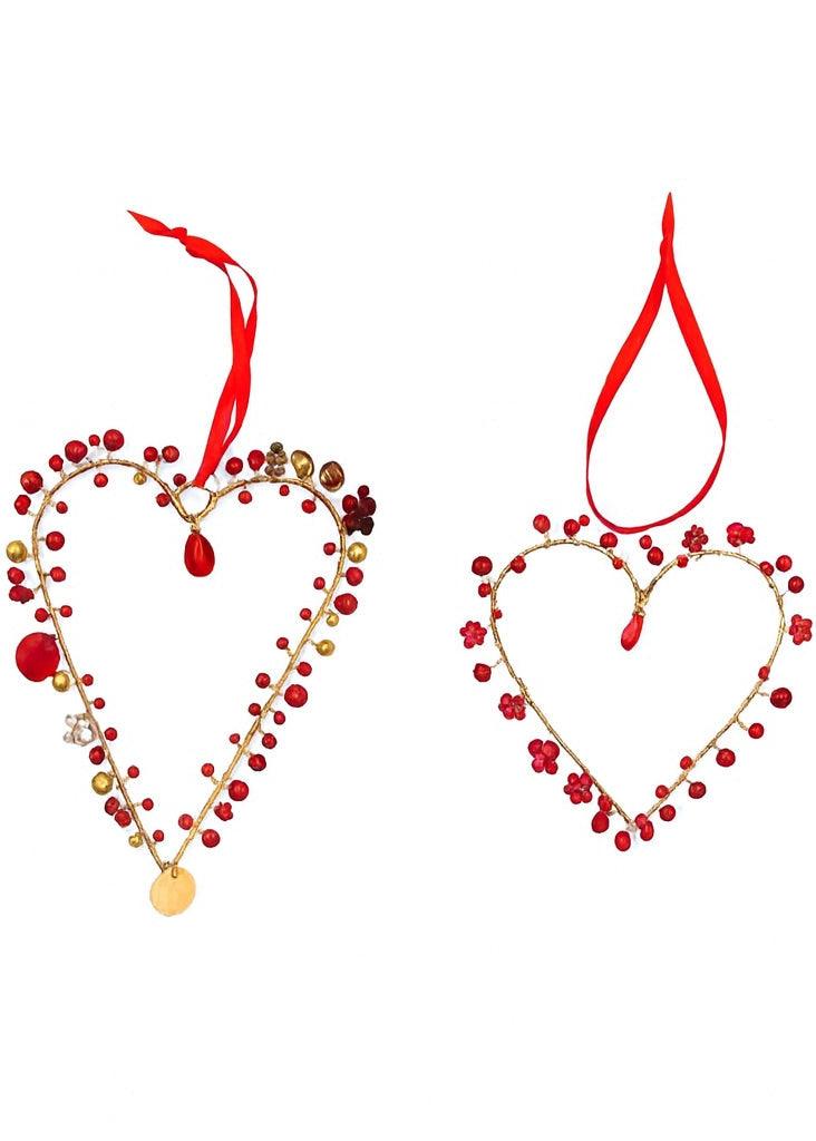Heart-shaped decorations with red and gold beads on a white background