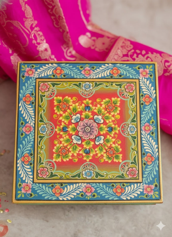 Colourful decorative box with floral patterns on a pink fabric background