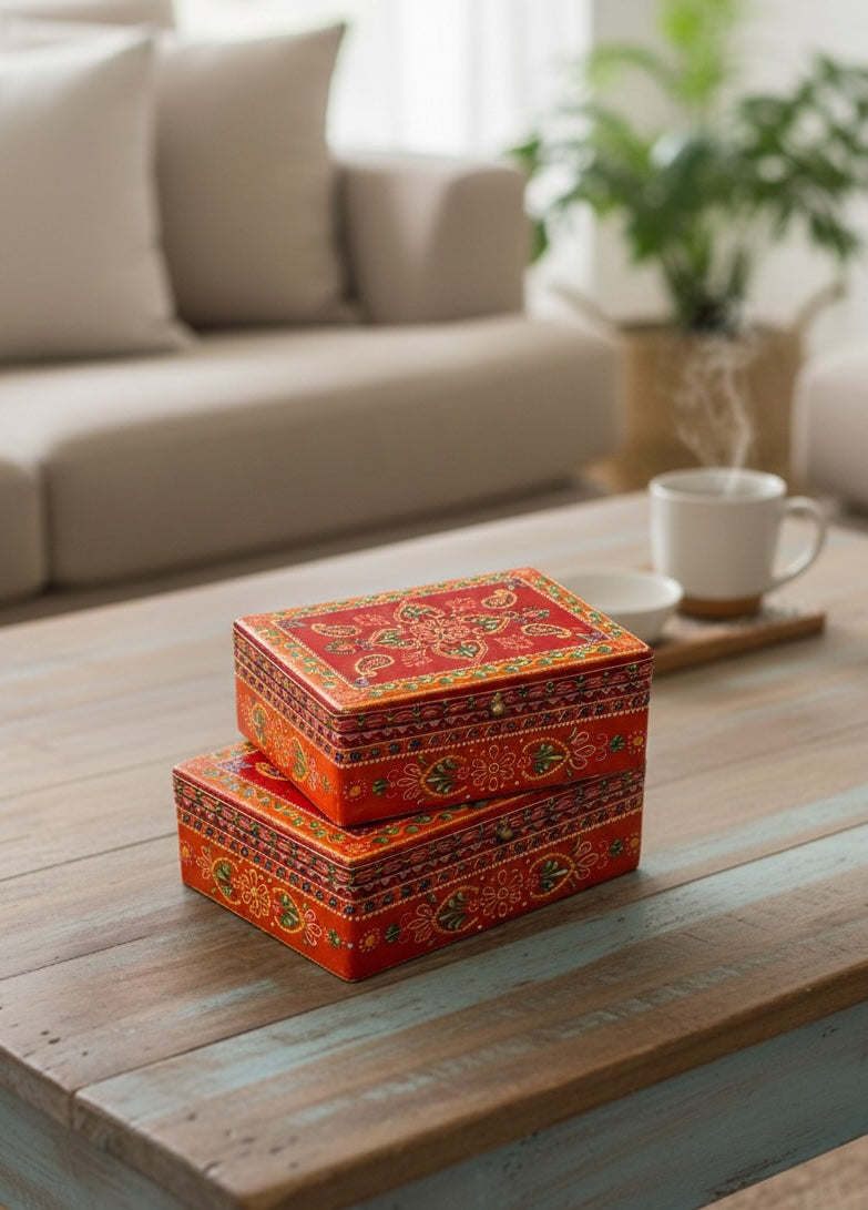 Stack of decorative orange boxes on a wooden table with a blurred living room background