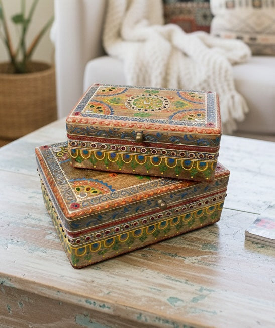 Decorative boxes with intricate patterns stacked on a wooden table