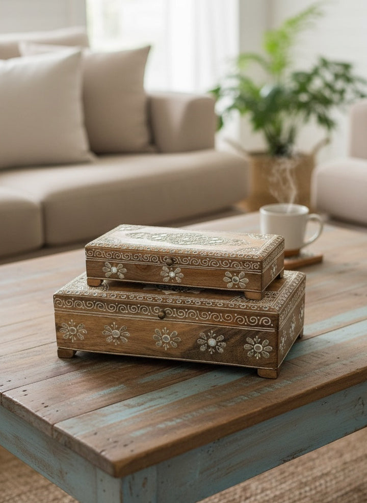 Decorative wooden boxes on a wooden table in a living room setting.