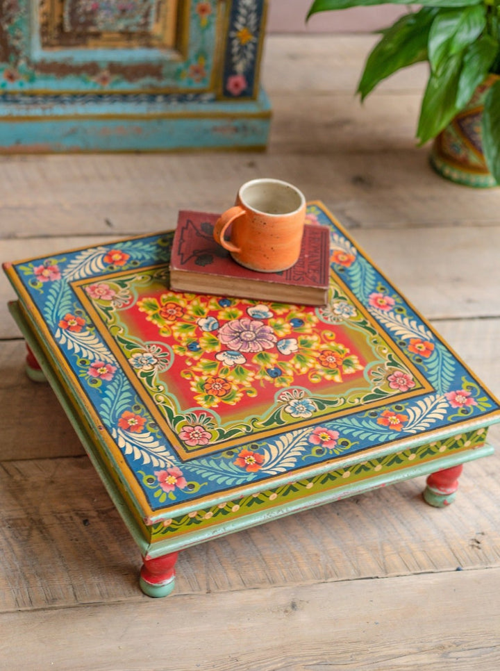 A indian bajot table a small side coffee table with a mug and a book