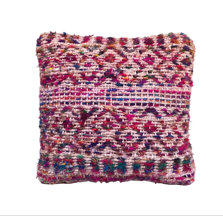 A square woven throw cushion featuring a multicolour pattern of pink, purple, red, and blue threads on a white background.