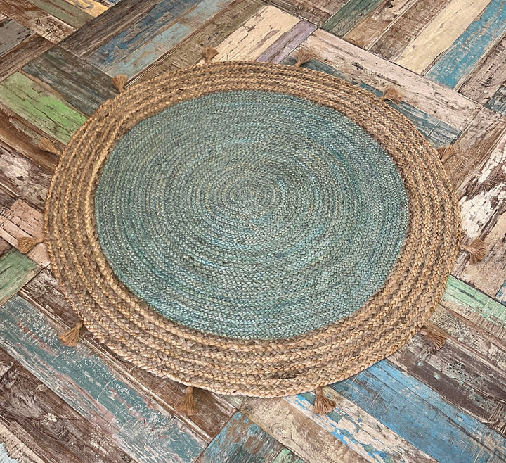 Round braided rug on a wooden floor with a rustic background