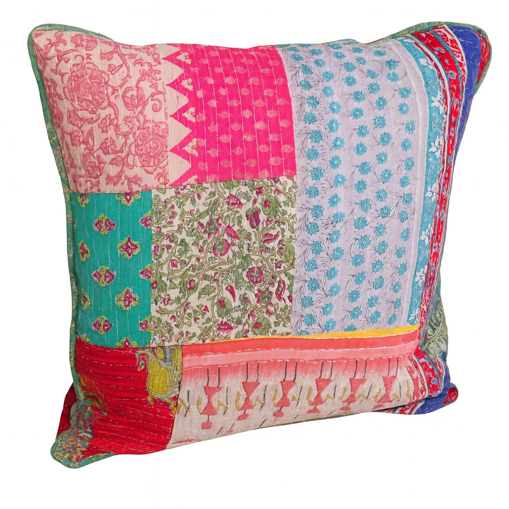 Multicolored patchwork pillow with floral and geometric patterns on a white background