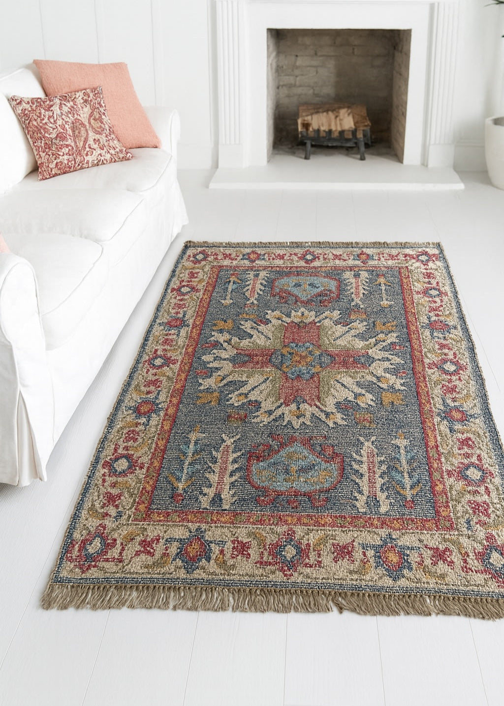 Decorative rug with intricate patterns on a white floor in a room with a fireplace.