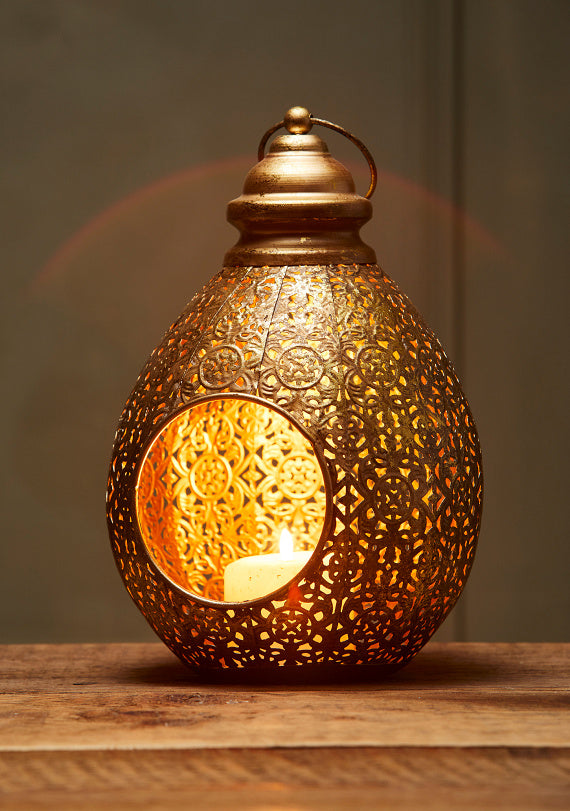 Decorative gold lantern with intricate patterns on a wooden surface