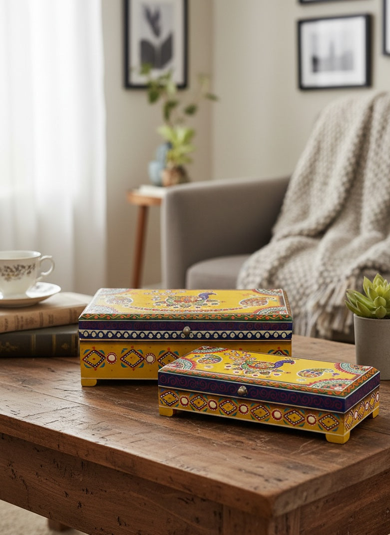 Decorative yellow boxes with purple patterns on a wooden table in a cosy living room.