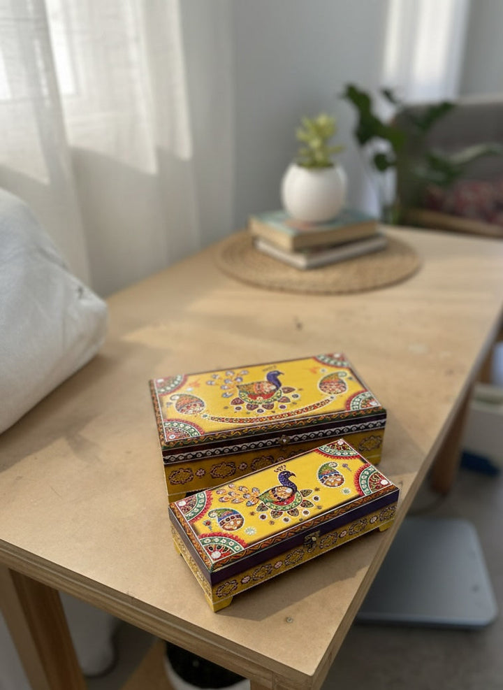 Indian Peacock yellow painted Indian Wooden Bxes on a table
