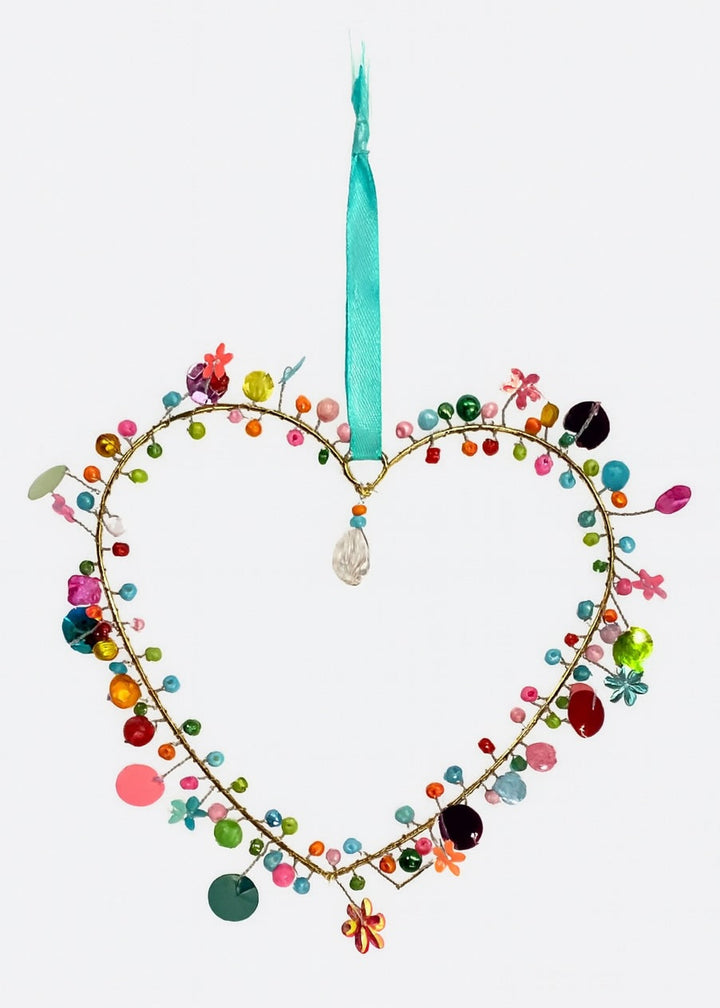 Heart-shaped hanging with coloruful beads and a turquoise ribbon on a white background